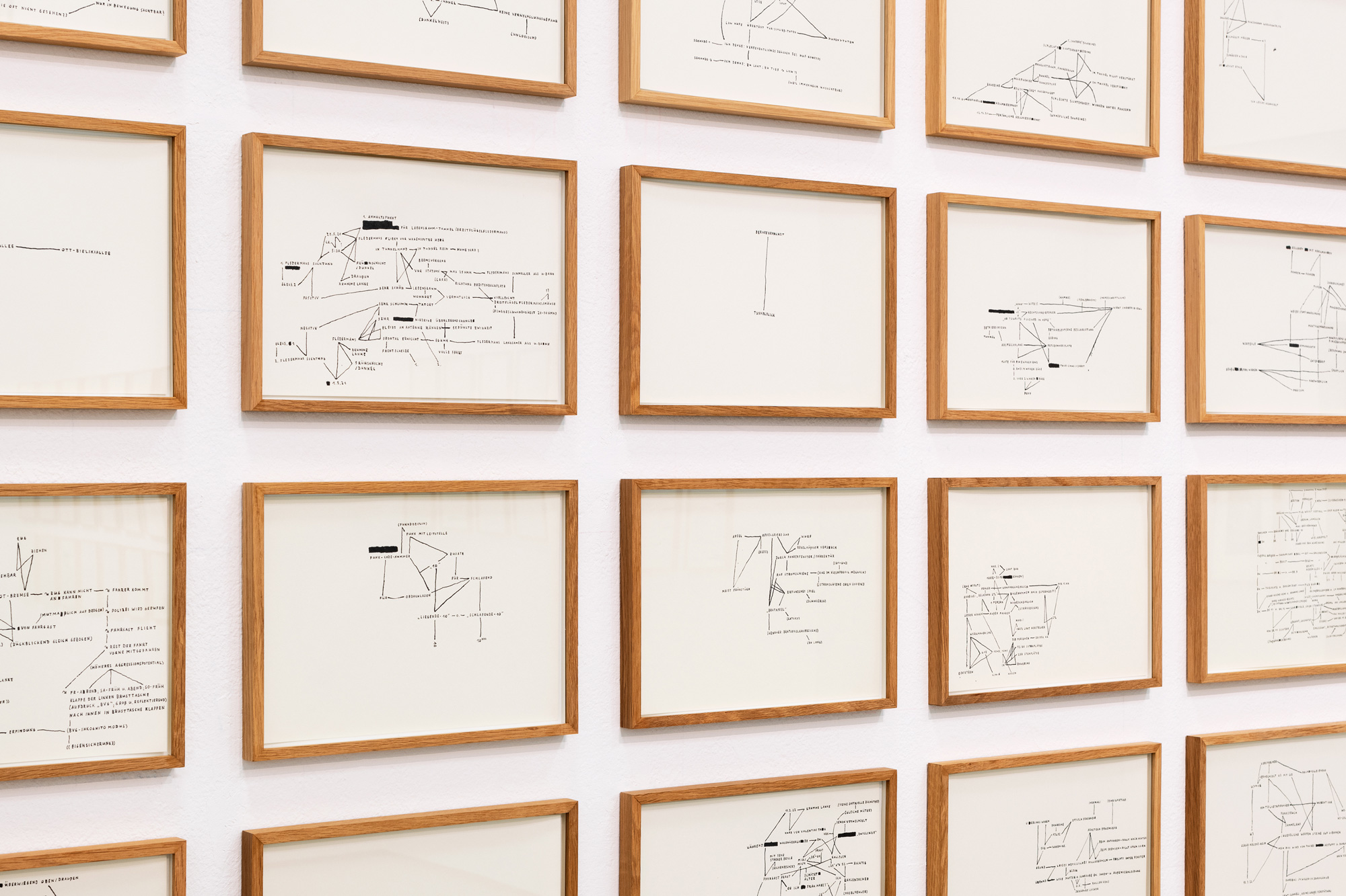Mehrere gerahmte Illustrationen an einer weißen Wand