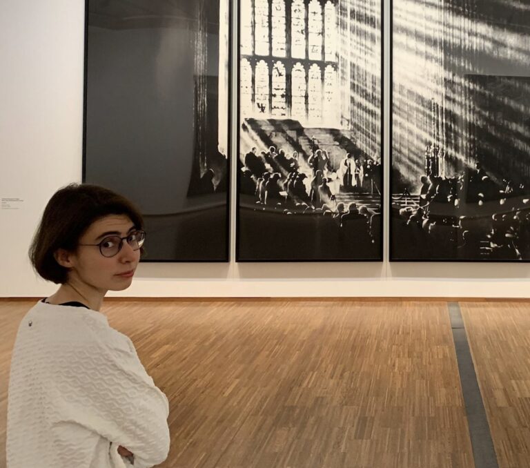 Das Bild zeigt die Autorin Maria Maiello im Profil vor einem Kunstwerk